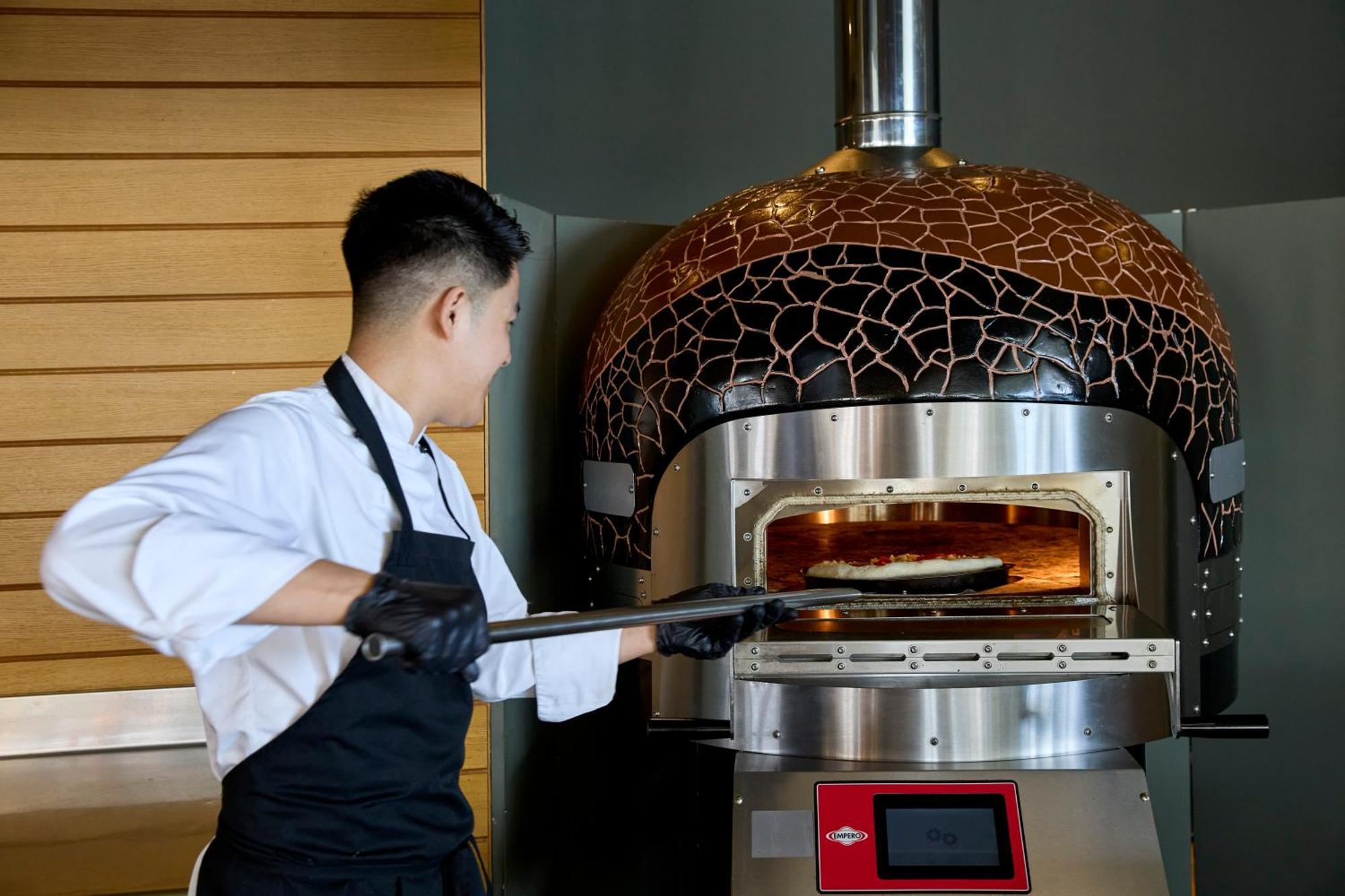 Dolce By Wyndham Athens Attica Riviera Hotel Vravrona Exterior photo A pizzaiolo baking a pizza in a wood-fired oven
